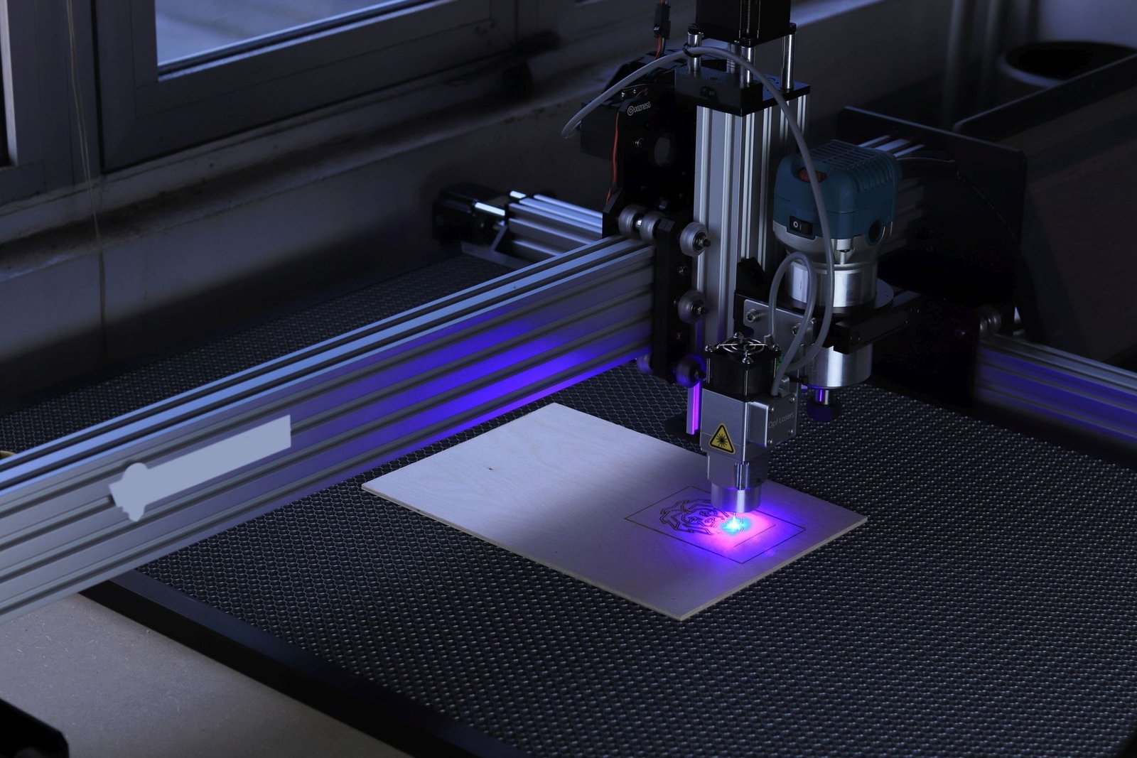 Laser engraving machine engraving a custom component from a CAD design for rapid prototyping and product development.